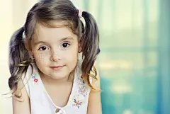Little girl  looking at camera. Small child closeup on  background.