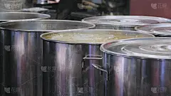 在这家东方餐厅的大锅里，煮拉面的肉汤正在沸腾