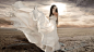 Фото Девушка в белом развевающемся платье на фоне облачного неба 
#GIF#  灬铃兰灬采集