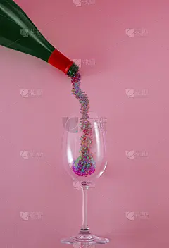 创意概念与绿色香槟瓶，心形闪光和粉红色背景玻璃。