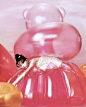 This may contain: a woman laying on top of an inflatable teddy bear with balloons surrounding her
