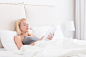 Young Caucasian woman reading in bed. by Matej Kastelic on 500px