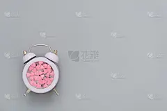 时间对于爱情的概念。美丽的明信片，俯视图。表盘上有粉红色的小心形图案。情人节贺卡
