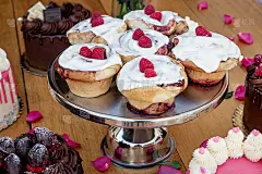 精致的肉桂和红色浆果放在银托盘上，周围是情人节蛋糕。