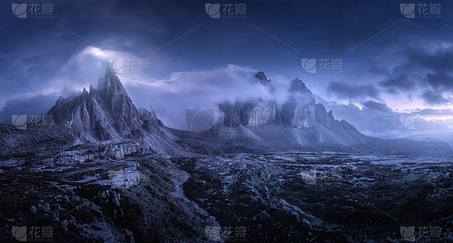 在美丽的夜晚，山在雾中。夏季景观有山谷、石头、小草、蓝天低云、星星和月亮。黄昏时高高的岩石。意大利D