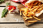 Tasty french fries on cutting board, on wooden table background :: Stock Photography Agency :: Pixel-Shot Studio