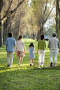 Three generations family walking at row of poplars