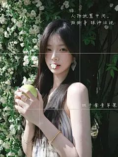 人物在画面中间，微微侧身，双手捧着青苹果，把清新感拉满，嘴边还衔着小花，增添灵动俏皮。周围白花绿叶衬托，满是夏日的清新