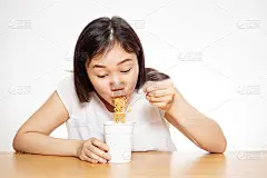 饥饿的女人吃着面条杯近距离