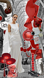 This may contain: a woman in white dress standing next to red decorations