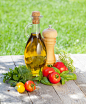 Fresh ripe tomatoes, olive oil bottle, pepper shaker and herbs摄影照片