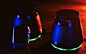 Two Bluetooth speakers and an Apple Watch in colorful lights