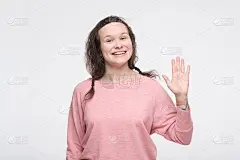 穿着粉红色衣服的女人挥手向她的朋友问好。