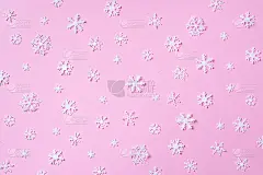白色雪花在粉红色的背景做成的冬季图案。前视图。平的。冬天的作文。圣诞节，新年的概念。