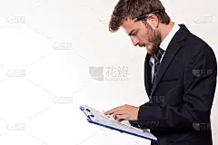 拿着剪贴板看平板电脑的商人