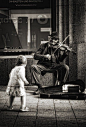 ZsaZsa Bellagio. Street musician performs while a child dances. Black and white photograph. #photography: 