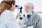 快乐的男性病人接受视力检查，由女性眼科医生