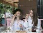 两个年轻女子在夏天的咖啡馆吃披萨