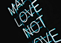 Blue neon light sign on black background reads Make Love Not Love