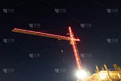 红色的彩带箭头照亮了塔吊的夜晚