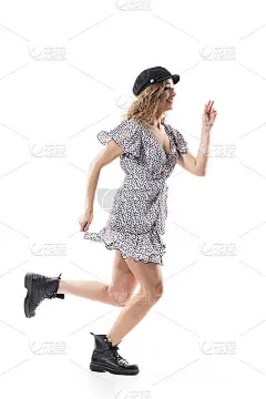 兴奋快乐热情的年轻女子穿着随风飘动的裙子奔跑着。侧视图。