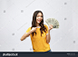 Closeup portrait of beautiful asian woman holding money isolated on white background. Asian girl counting her salary dollar note. Success wealth financial business cashflow currency payment concept