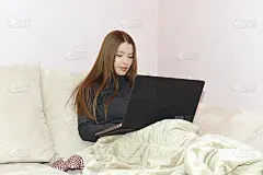 漂亮的年轻女子在用她的笔记本电脑。