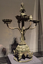 an ornate metal object on display in a glass case