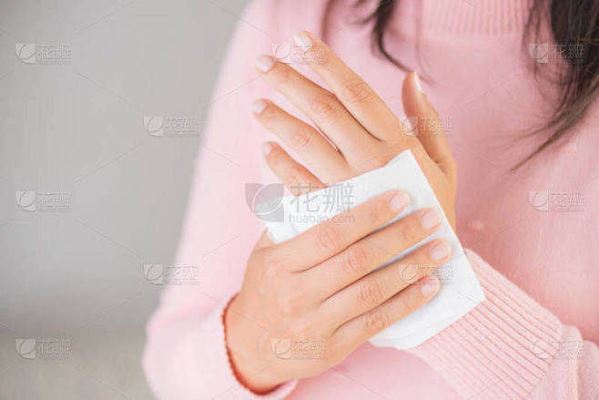 女人用纸巾擦手。医疗保健理念.