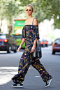 Karlie Kloss in an off-the-shoulder Fendi floral jumpsuit paired with a Tom Ford bucket bag and red lipstick.: 