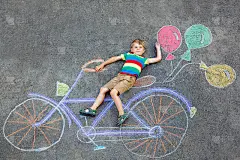 小男孩玩自行车粉笔画在地上