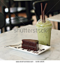 Dark chocolate cake and green tea in the cafe - stock photo