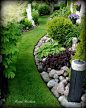 beautiful curved flower bed with rock garden and plantings that add color and texture.: 