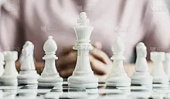棋盘上摆着白色的象棋图片，把下棋的概念比作企业管理。商人下棋被比作商业计划和解决问题。