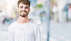 年轻英俊的男子戴着太阳镜在孤立的背景与快乐和凉爽的微笑在脸上。幸运的人。