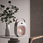 This may contain: an air purifier sitting on top of a table next to a potted plant