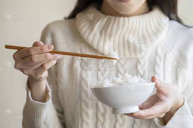 女人拿着白米饭和筷子在碗里 