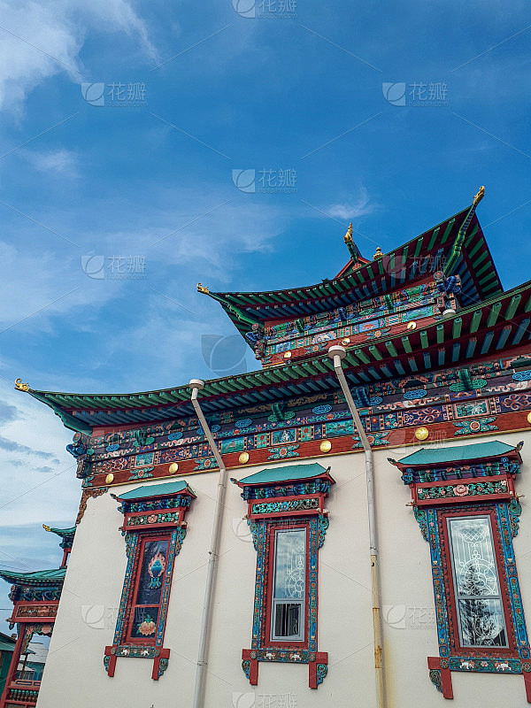 佛教寺院，美丽的宗教建筑，五颜六色的木雕，象征性的装饰，花云和夏天明亮的蓝天
