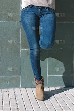 穿着牛仔裤和靴子的都市女孩的腿