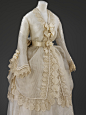 #服装# 婚服，1872~1874，白色薄纱与丝缎相间的细条纹布料，装饰奶油色刺绣蕾丝花边与缎带花结，虽然整体看来层层叠叠很复杂，但因为布料半透明的质感，所以感觉还是挺轻盈的~ ​​​​