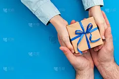 小儿子给父亲一个礼物盒。概念父亲节或生日贺卡。