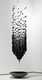Suspended black fragments create a dramatic effect as the visual density gradually dissipates above.