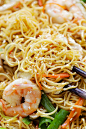 Chow Mein noodles stir-fried with shrimp, chicken and vegetables in a skillet.