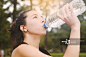 Portrait of sportswoman drinking water after workout_创意图片