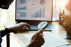 用放大镜看文件的商人。业务评估和审计。财务报告上的放大镜。商人用放大镜检查账单的特写。搜索的概念。