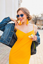 beautiful-smiling-woman-yellow-stylish-dress-wearing-denim-jacket-trendy-outfit-spring-summer-fashion-trend-sunny-happy-mood-blue-sunglasses-street-fashion