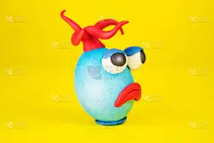 复活节彩蛋卡通人物与橡皮泥眼睛，嘴和头发有一个富有表情的脸