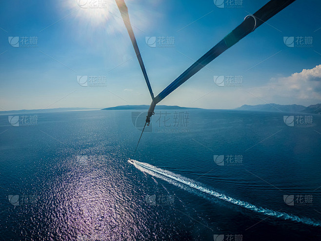 一对快乐的情侣在夏天的海面上跳伞