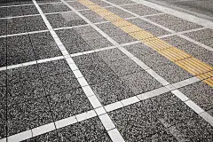 白色和黄色的道路标记线在灰色的鹅卵石铺面上