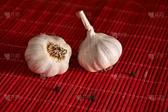 红木桌上放着大蒜和黑胡椒。干香料混合